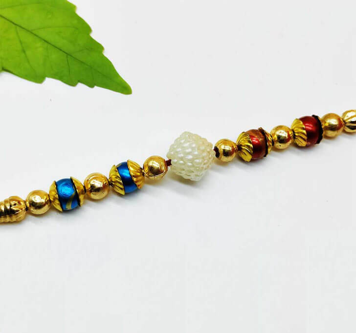 Buy Golden Beads White Pearl Center Piece Bhaiya Rakhi